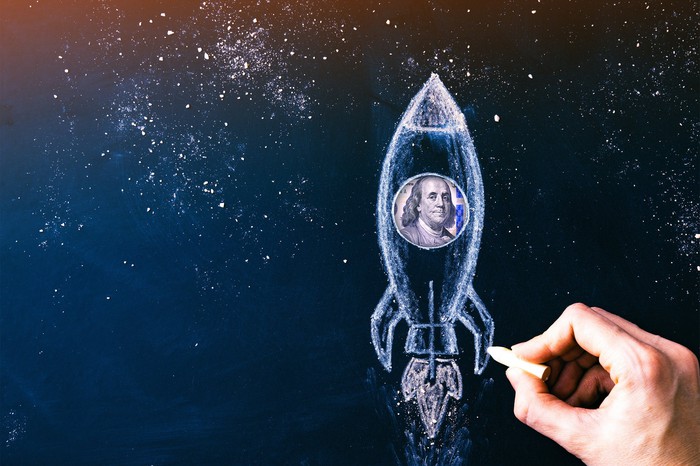 Hand drawing a rocket with Ben Franklin in it.